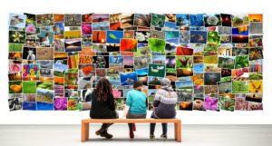 Drei Personen auf einer Bank sitzend vor einer bunten Fotocollage
